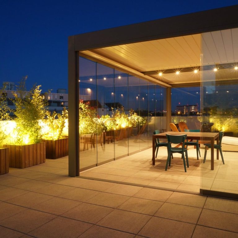 Terrasse moderne avec éclairage doux sous la pergola bioclimatique, meubles en bois et verdure, ambiance nocturne apaisante. Terrasse moderne avec éclairage doux sous la pergola bioclimatique, meubles en bois et verdure, ambiance nocturne apaisante.